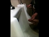 two slim dicks getting wanked at the urinals