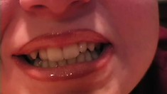 Her fat and juicy lips glisten as she softly covers them with gloss