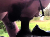 Bearded bear sucks black cock outdoor